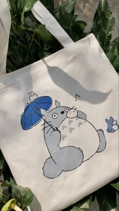 a tote bag with a cartoon cat holding an umbrella