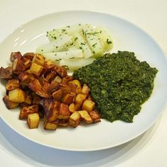 a white plate topped with potatoes and spinach