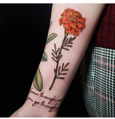 a woman's arm with an orange flower on it and the words grow through you go through