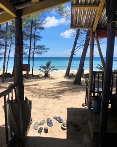 sandals are laying on the sand under some trees