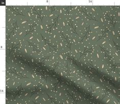 an image of a green fabric with white dots and leaves on the back, in front of a ruler