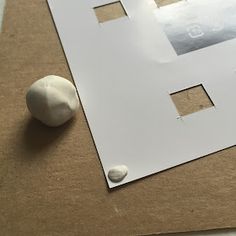 a piece of paper with holes in it next to a white object on the ground