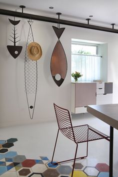 a room with several hanging objects on the wall and a table in front of it