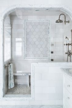 a bathroom with white walls and marble flooring next to a bathtub in the corner