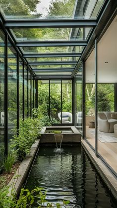 the inside of a glass house with a pond