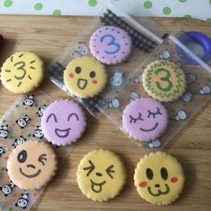 cupcakes decorated with smiley faces and numbers are on a table next to other decorations