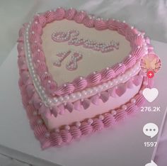 a pink heart shaped cake with pearls on it