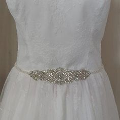 a white wedding dress with a silver belt