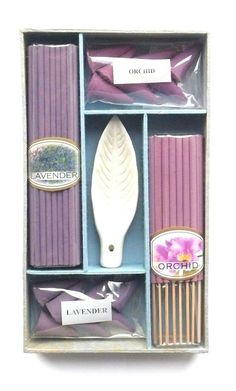 an open box with lavender candles and other items in the inside, including a spatula