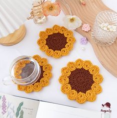 three crocheted sunflower coasters sitting on top of a table