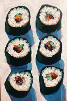 four sushi rolls are arranged on top of each other in blue plates, with white frosting and toppings