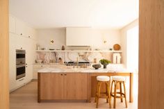 a kitchen with marble counter tops and wooden stools