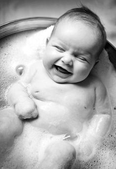 a laughing baby in a bath tub