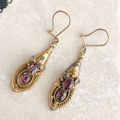 A Vintage pair of 9 carat gold dangle earrings displaying amethysts and chrysoberyl stones. The design of the setting really frames the stones perfectly with plenty of detail, making the colour of those stones pop! What a stunning pair! CONDITION: Wear consistent with age and use. Please see photos for more detail. APPROX. DROP (LENGTH): 50mm AMETHYST STONE SIZE: 4mm x 6mm CHRYSOBERYL SIZE: 4mm x 2mm WEIGHT: 7.0grams (DDZ) Antique Jeweled Formal Earrings, Antique Jeweled Earrings For Formal Occasions, Victorian Gemstone Earrings For Anniversary, Victorian Jeweled Earrings For Formal Occasions, Victorian Jeweled Earrings Gift, Vintage Multi-stone Earrings For Gift, Gold Diamond Band, Yellow Gold Diamond Ring, Gold Dangle Earrings