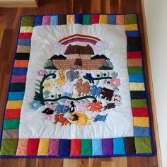 a colorful quilt is on the floor in front of a wall