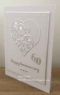 an anniversary card with a heart and flowers on the front, sitting on a table