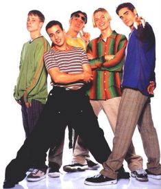 a group of young men standing next to each other in front of a white background