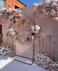 a pink backdrop with flowers and candles for a wedding or bridal party in front of a building