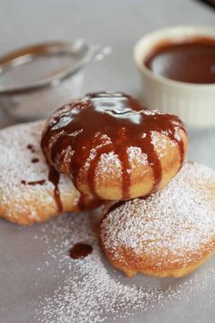 three sugar donuts with chocolate sauce on top