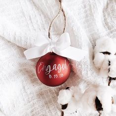 a red ornament hanging from a cotton ball