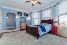 a bedroom with blue walls and white carpet