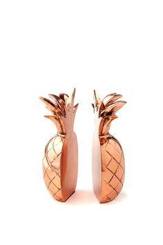 two metal pineapples sitting next to each other