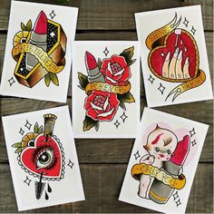 four cards with tattoos on them sitting next to some paintbrushes and pencils