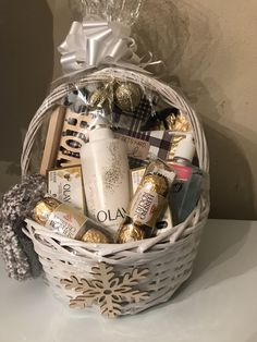 a white basket filled with lots of different types of holiday treats and chocolates on top of a table