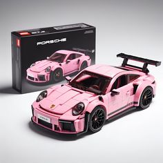 a pink lego porsche sports car next to a box