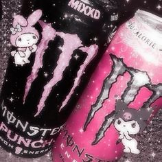 two pink monster energy drinks are sitting on the ground next to each other and one has an image of a cat