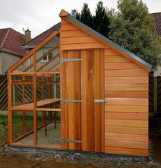 a small wooden building with a greenhouse attached to it's roof and side walls