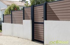 a brown and white fence next to a house