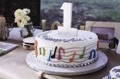 a birthday cake decorated with musical notes and the number one on top is for someone's first birthday