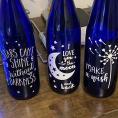 three blue glass bottles with writing on them