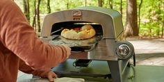 a woman is cooking food on an outdoor grill