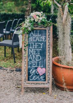 a chalkboard sign that says all because they met and fell in love next to a potted plant