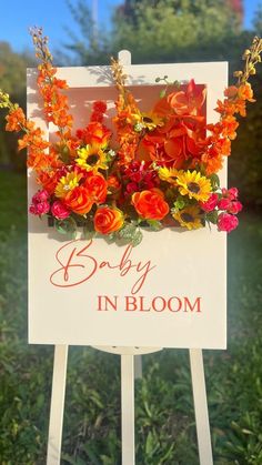 a sign with flowers on it that says baby in bloom