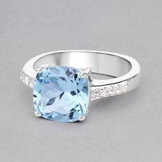 "Blue Topaz Ring, Natural Sky Blue Topaz Cushion Cocktail Ring, Sky Blue Topaz Silver Ring, December Birthstone Ring, Topaz Birthstone Ring Flaunt yourself with this blue & white topaz cocktail ring. The natural gemstones have a combined weight of 4.62 carats and are set in .925 sterling silver with rhodium plating. The soft blue hue of this ring adds a pop of color to any look! The understated design and vibrant stones make this ring perfect for every occasion. .925 Sterling Silver Stone De Blue Topaz Ring With Gemstone Accents, Blue Topaz Ring With Accent Stones, Fine Jewelry Blue Topaz Ring With Accent Stones, Blue Topaz Rings With Gemstone Accents, Blue White Topaz Ring With Gemstone, Blue White Topaz Ring For Promise, Blue Topaz Crystal Ring With Gemstone Accents, Light Blue Topaz Rings With Diamond Accents, Light Blue Cubic Zirconia Ring With Gemstone