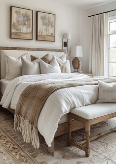 a bed with white linens and pillows in a bedroom next to a large window