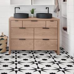 a bathroom with black and white tiles on the floor, two wooden sinks and open shelving