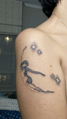 a woman with a tattoo on her shoulder is looking at the stars in the sky