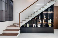 the stairs are lined with vases and other decorative items on display behind glass shelves