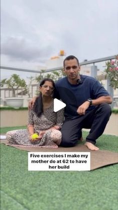 a man and woman sitting on top of a mat with a tennis ball in their hand