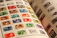 an open book with stamps on it and the pages are multicolored in different colors