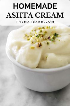 a white bowl filled with cream and pistachio