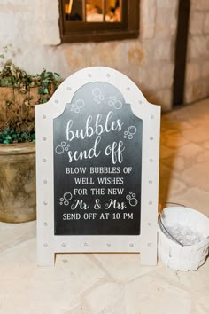 a sign that says bubbles send off below it is next to a potted plant