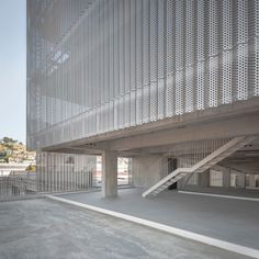 an empty parking garage with stairs leading up to the building's upper floor area