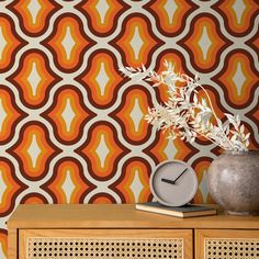 an orange and white wallpaper with a plant in a vase on top of it