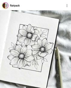 an open notebook with flowers drawn on it and a pen next to the book cover