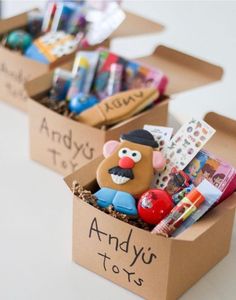 two cardboard boxes filled with toys on top of a table